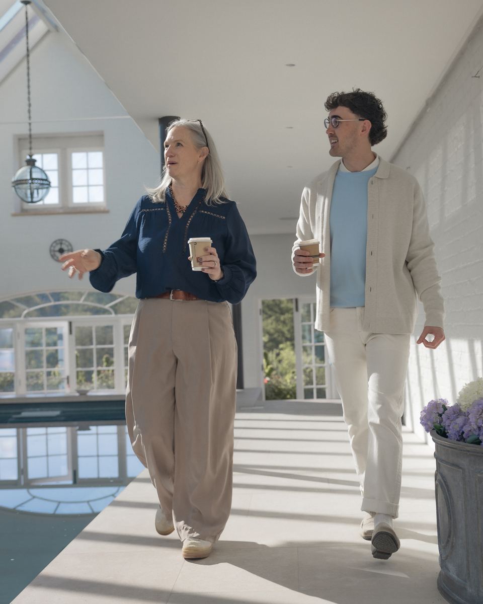 Lindsay and Lewis walking through the studio with coffee